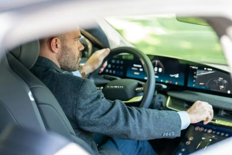 Homme conduisant une voiture électrique en France, vu de dos