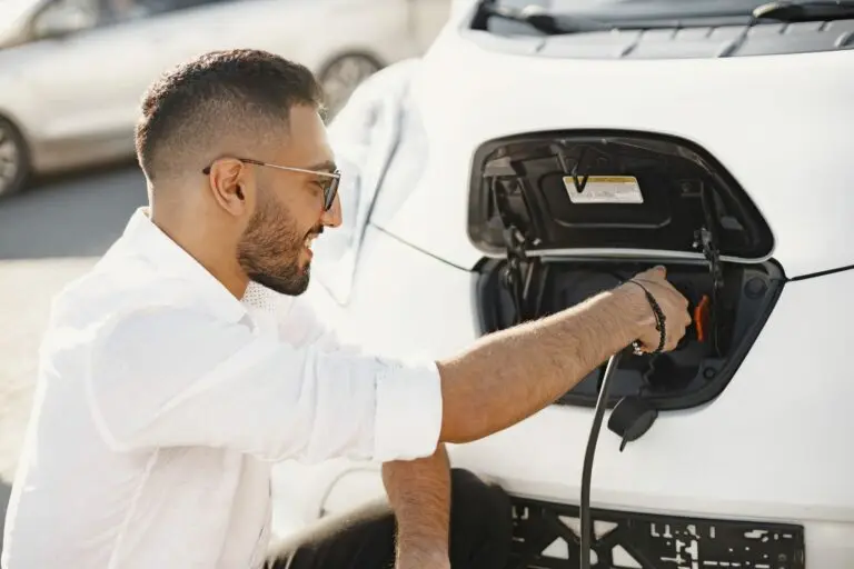 Jeune homme rechargeant sa voiture électrique, symbole de l’électromobilité urbaine et durable.