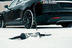 Voiture électrique en charge sous la neige pendant l’hiver