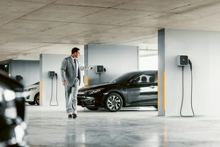 Man leaving his electric vehicle connected to a home charging point