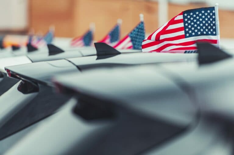 Electric vehicles parked in front of American flags, representing the US EV market.